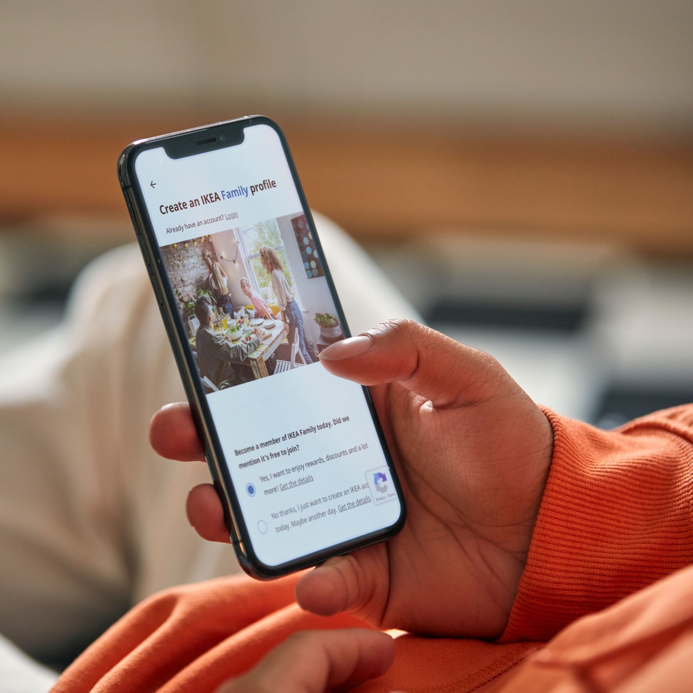 A close-up of a person's hand creating an IKEA Family account on their mobile phone.