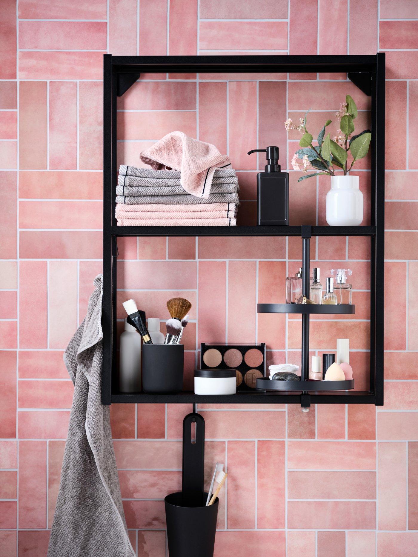 Módulo de pared de azulejos con un estante y estante giratorio ENHET, con toallas VIKFJÄRD y accesorios de maquillaje.