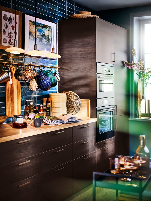 A kitchen with a SMYCKA artificial bouquet on the windowsill.