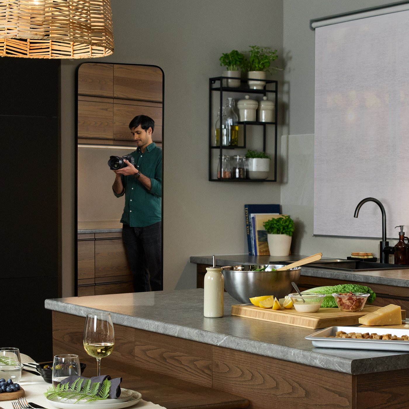a person standing in front of a mirror taking a picture of a kitchen