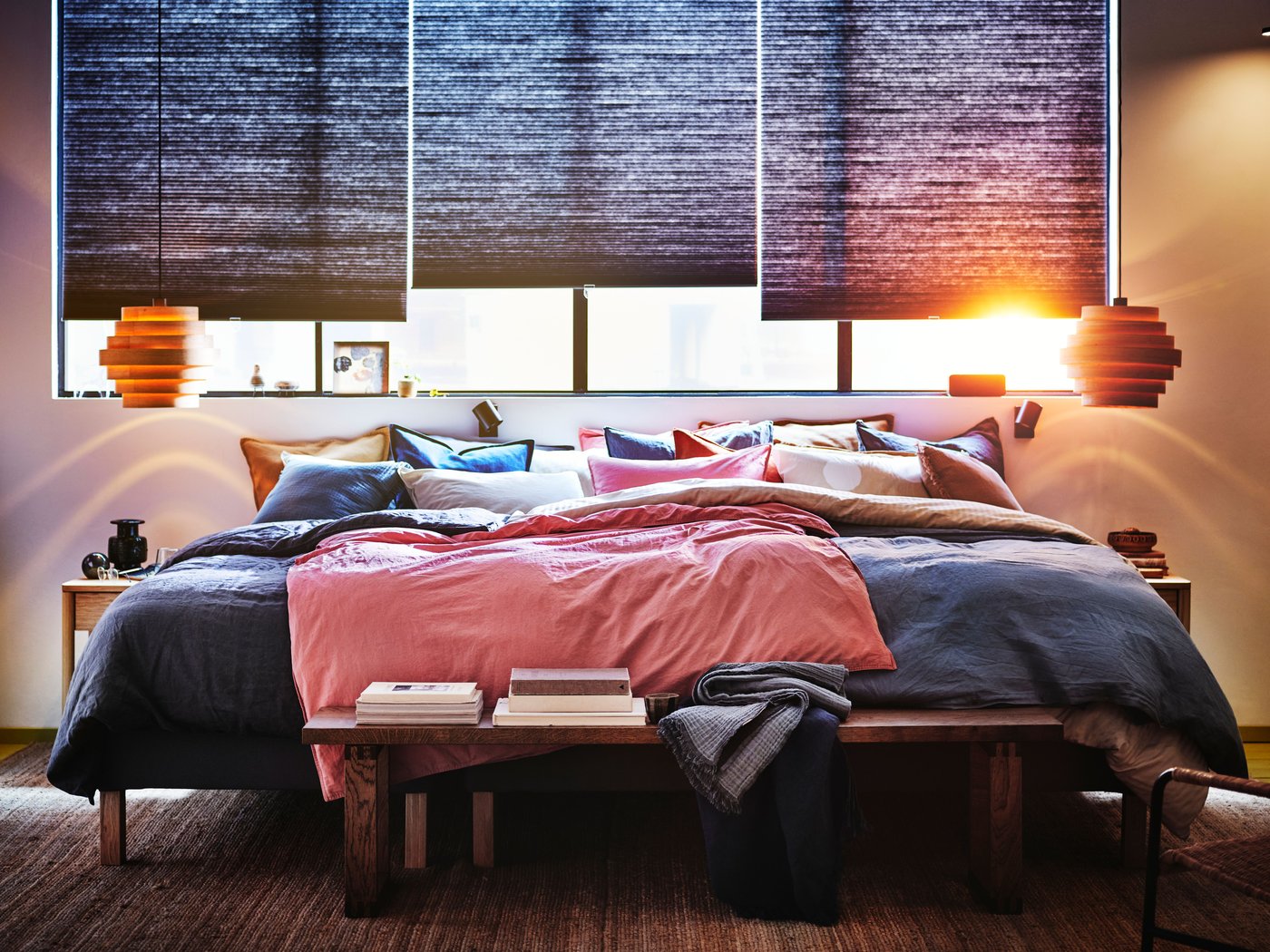 En vitbetsad ekfaner DYKARKLOCKA hänger i ett romantiskt sovrum med en stor säng som har gråa och rosa sängkläder.