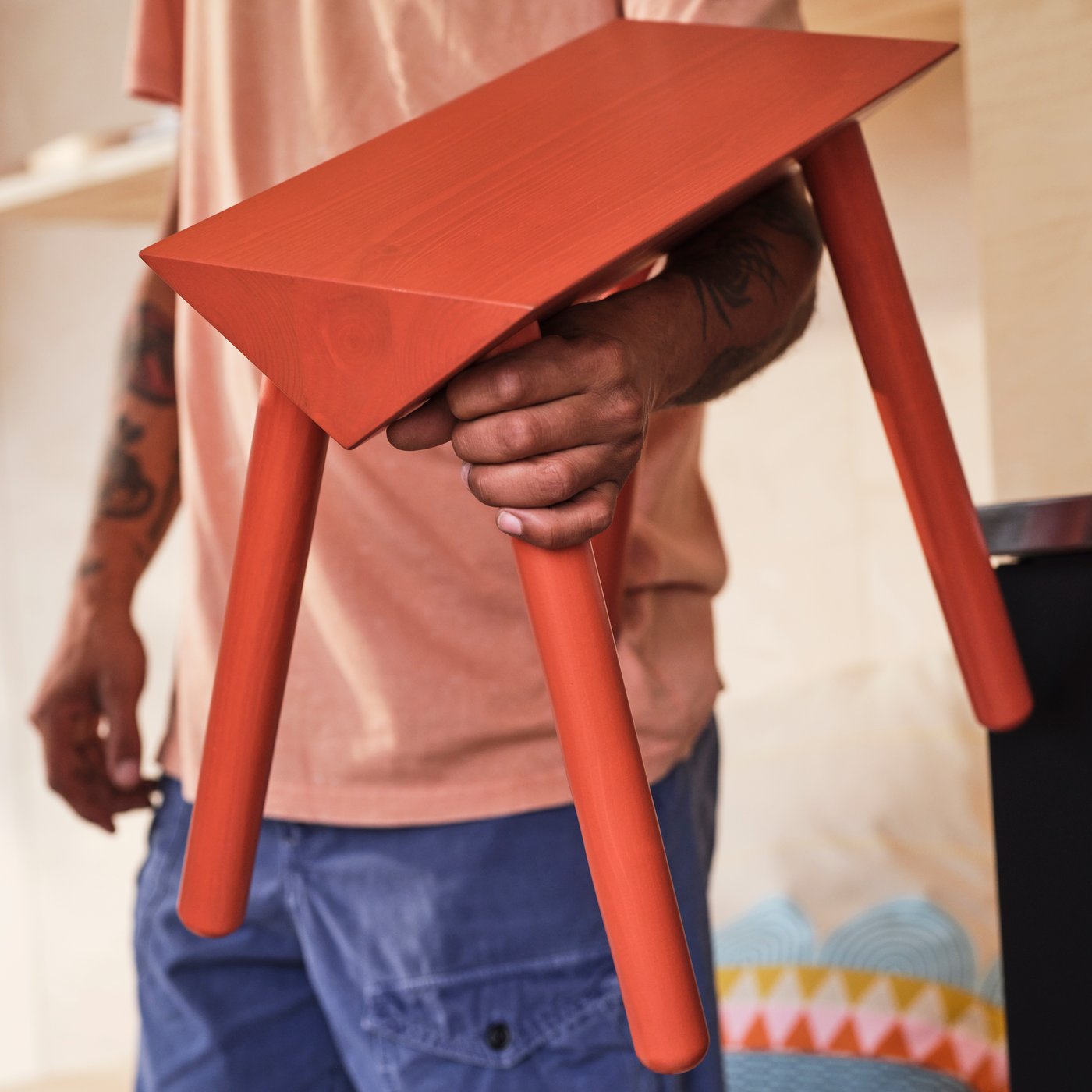 An orange-red/stained OMMJÄNGE stool