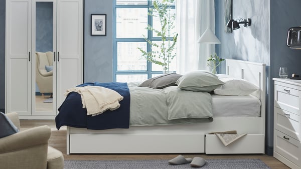 A black SKURUP wall lamp in the bedroom
