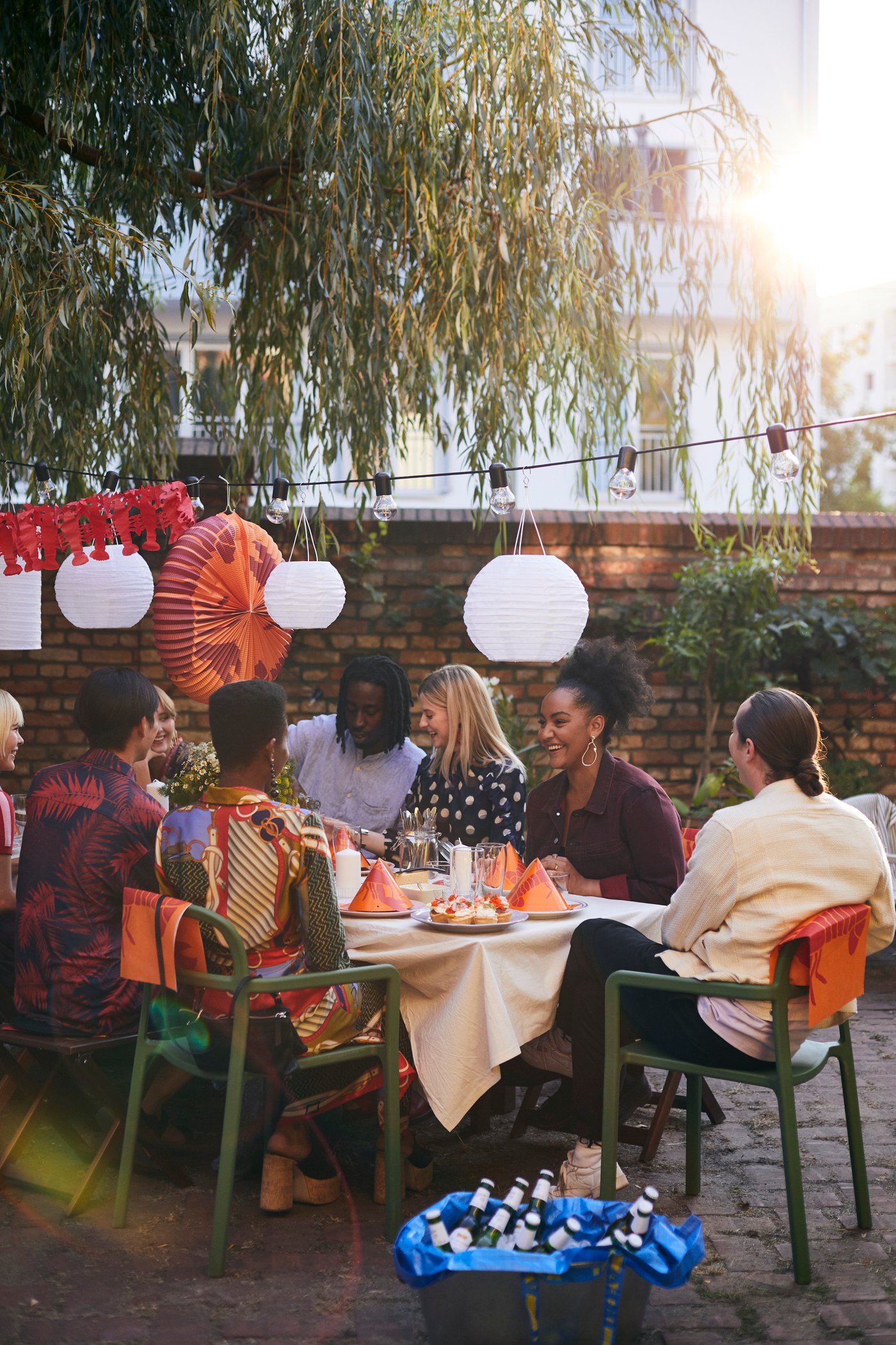 A group of friends sitting at a dining table in a backyard enjoying a crayfish feast.