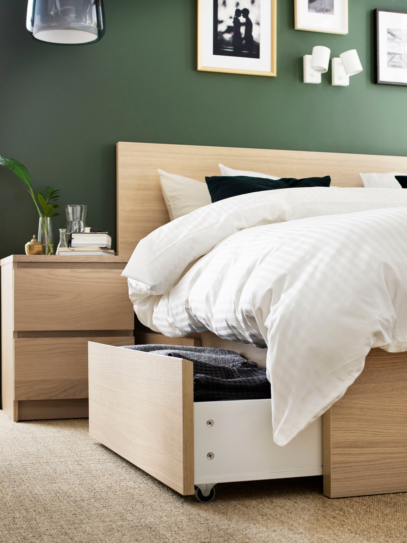A white MALM dresser with a lamp on top against a wooden wall background.