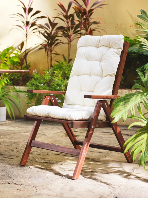 An outdoor chair with KUDDARNA seat/back pad on top of it.