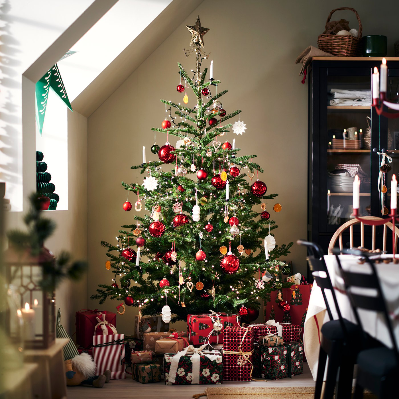 A VINTERFINT artificial Xmas tree with classic red VINTERFINT tree decorations with presents underneath.