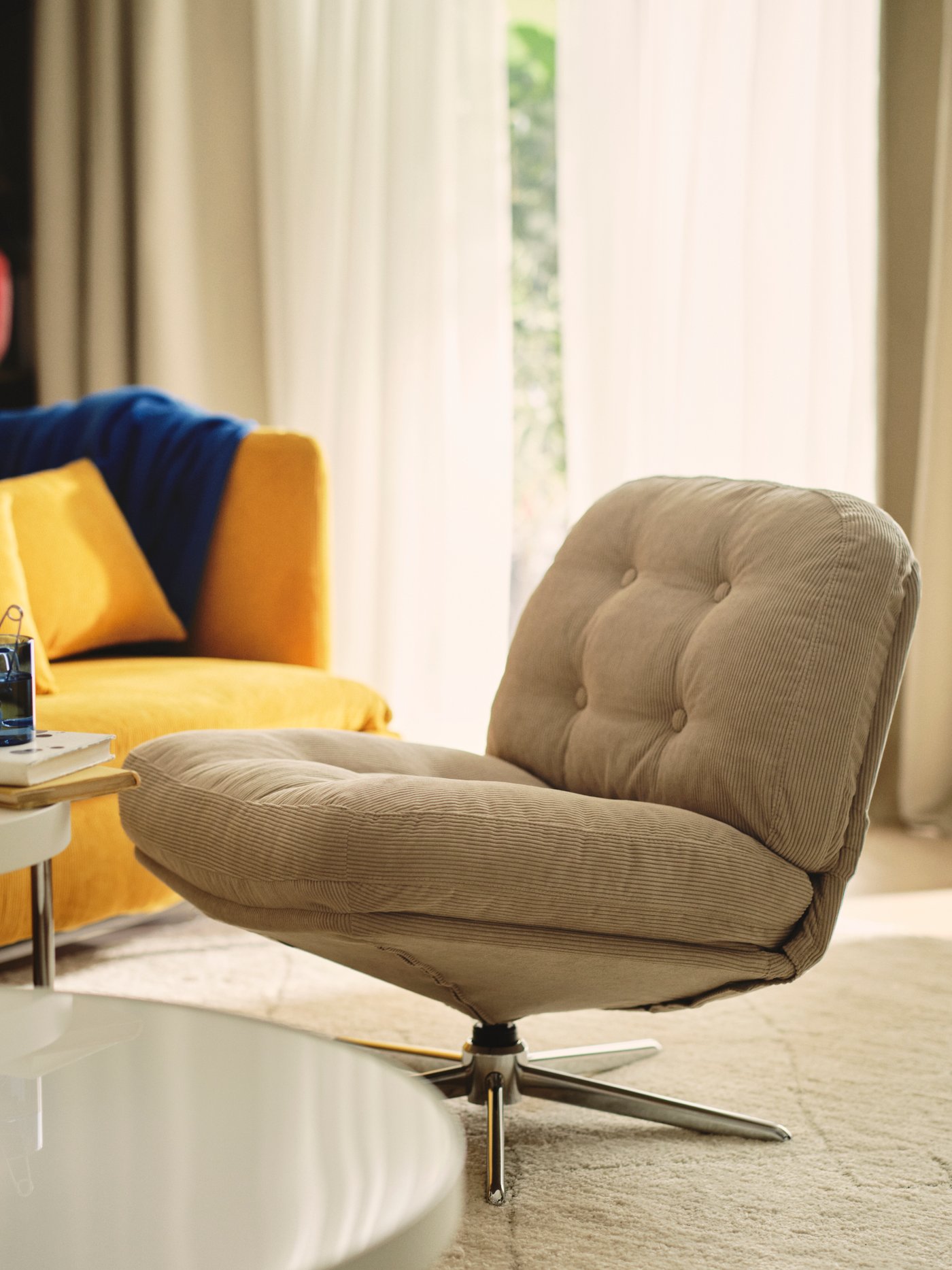 Living room with a DYVLINGE swivel easy chair, a coffee table and a yellow sofa.