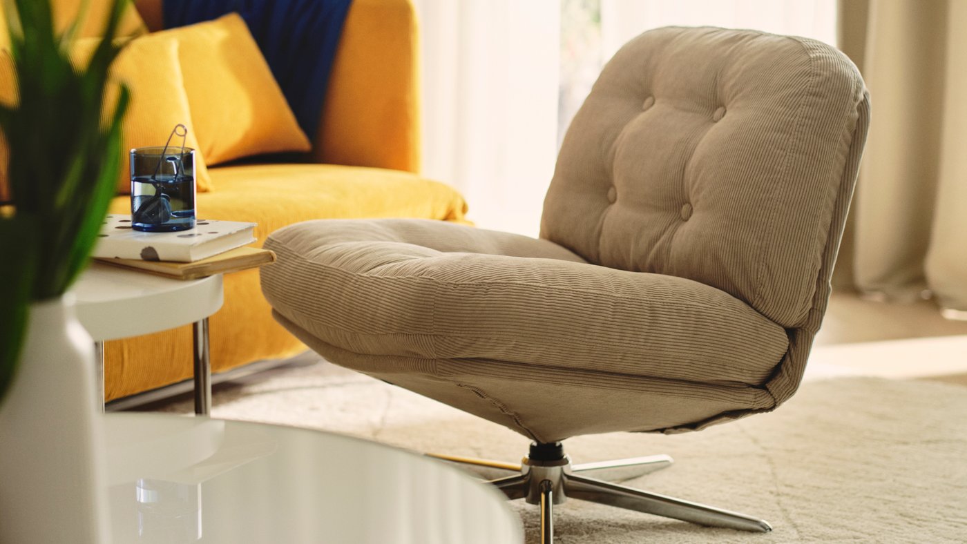 Living room with a DYVLINGE swivel easy chair, a coffee table and a yellow sofa.