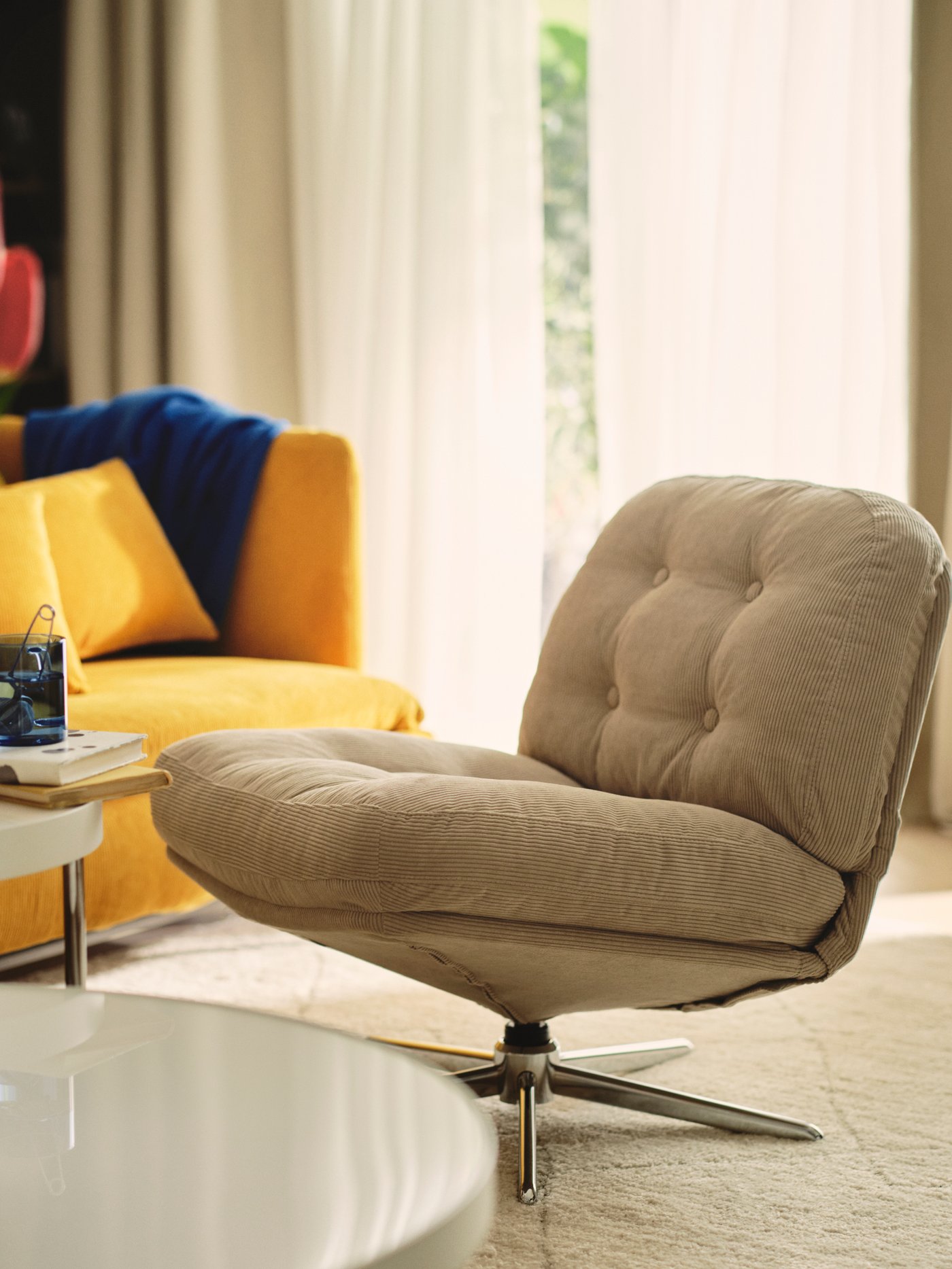 Living room with a DYVLINGE swivel easy chair, a coffee table and a yellow sofa.