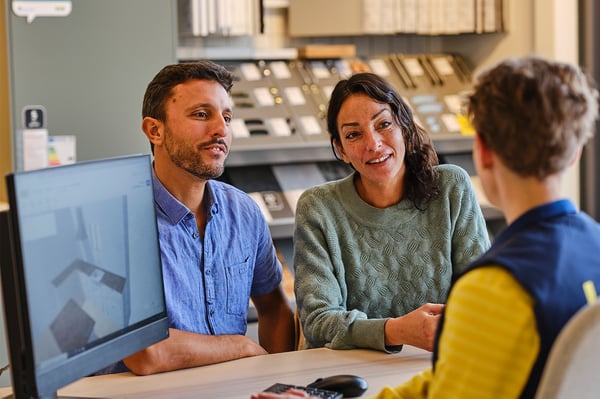 Ein IKEA Mitarbeiter vor zwei Kunden