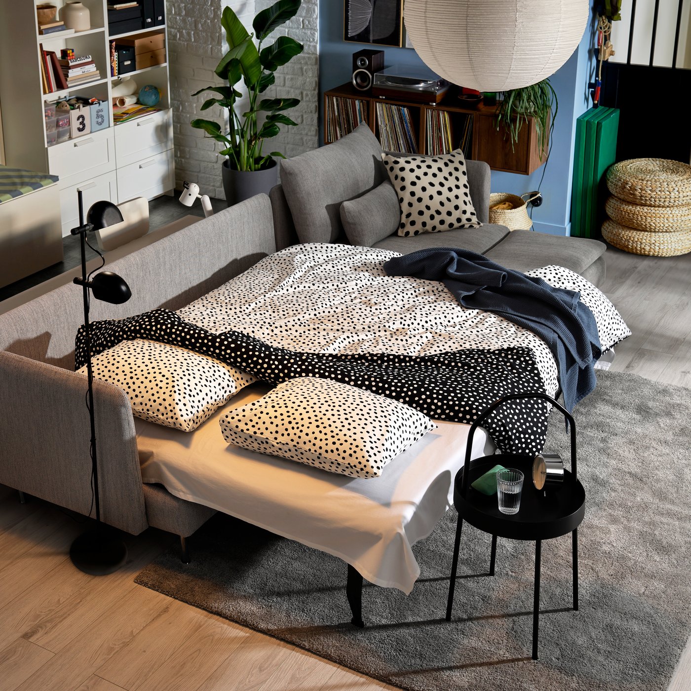 Divano letto SÖDERHAMN 4 posti con chaise-longue, rivestito in tessuto VIARP grigio, aperto in versione letto e pronto per la notte con biancheria coordinata.