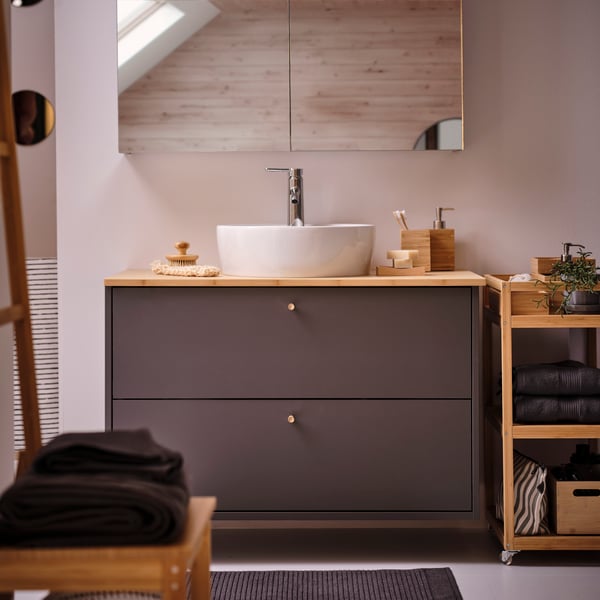 A dark grey HAVBÄCK wash-stand with drawers in the bathroom