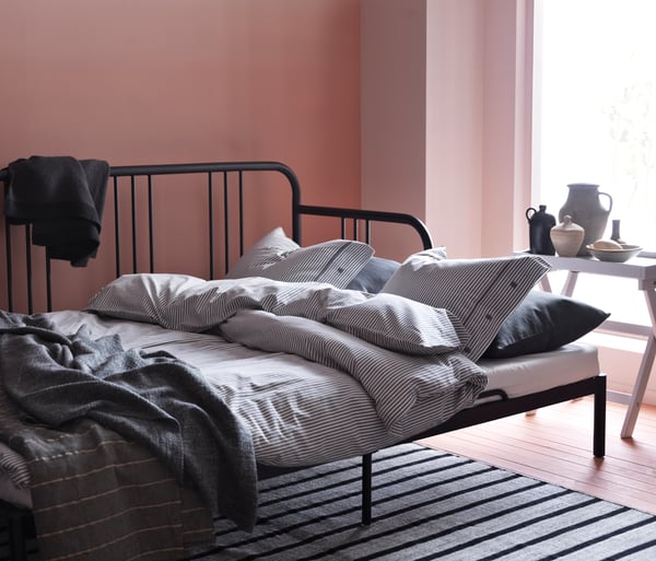 A black FYRESDAL day-bed frame in the living room
