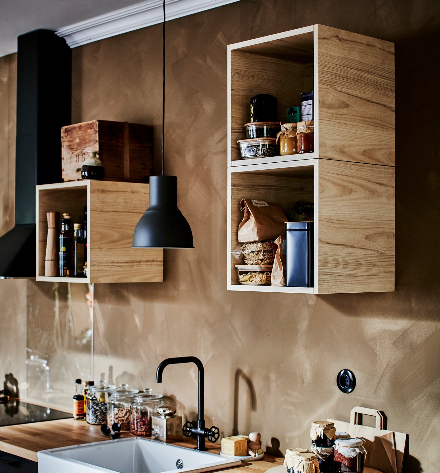 Die TUTEMO Schränke mit verschiedenen Küchenutensilien, in unregelmässigen Abständen über einer Küchenzeile verteilt.