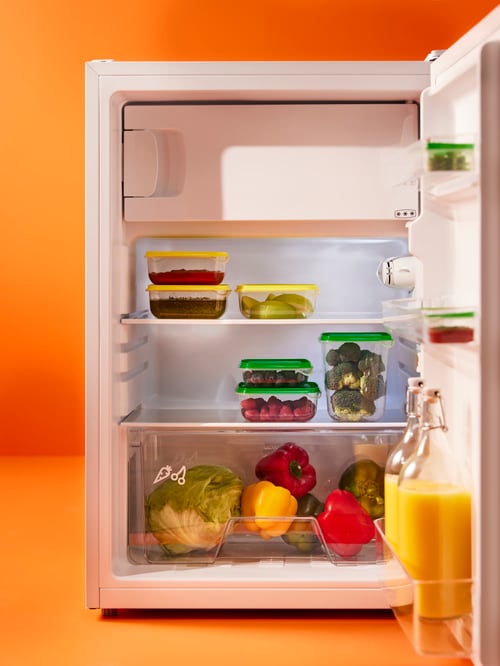 Kitchen featuring a LAGAN fridge with freezer compartment storing 2 KORKEN bottles with stopper and 3 PRUTA food containers.
