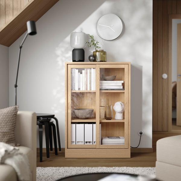 An oak veneer TONSTAD cabinet with sliding glass doors