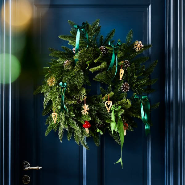 An in/outdoor/pine cone green VINTERFINT artificial wreath on a blue door.