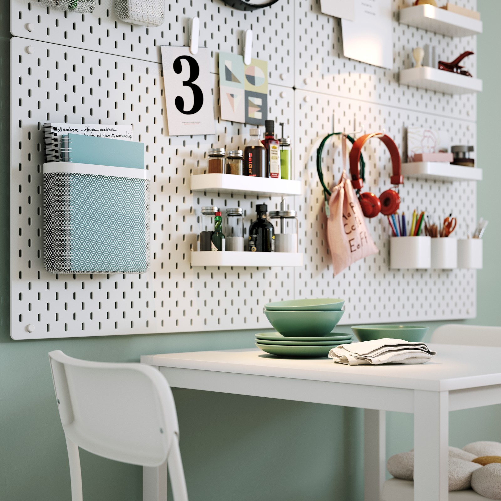 Unha mesa VIHALS branca con dúas cadeiras arredor, situada nunha luminosa cociña con adornos e taboleiros perforados SKÅDIS.