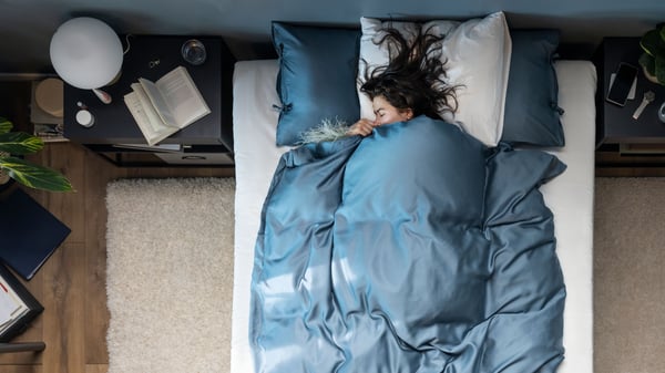Ein weißer VOLLERSLEV Teppich, Langflor unter einem Bett.