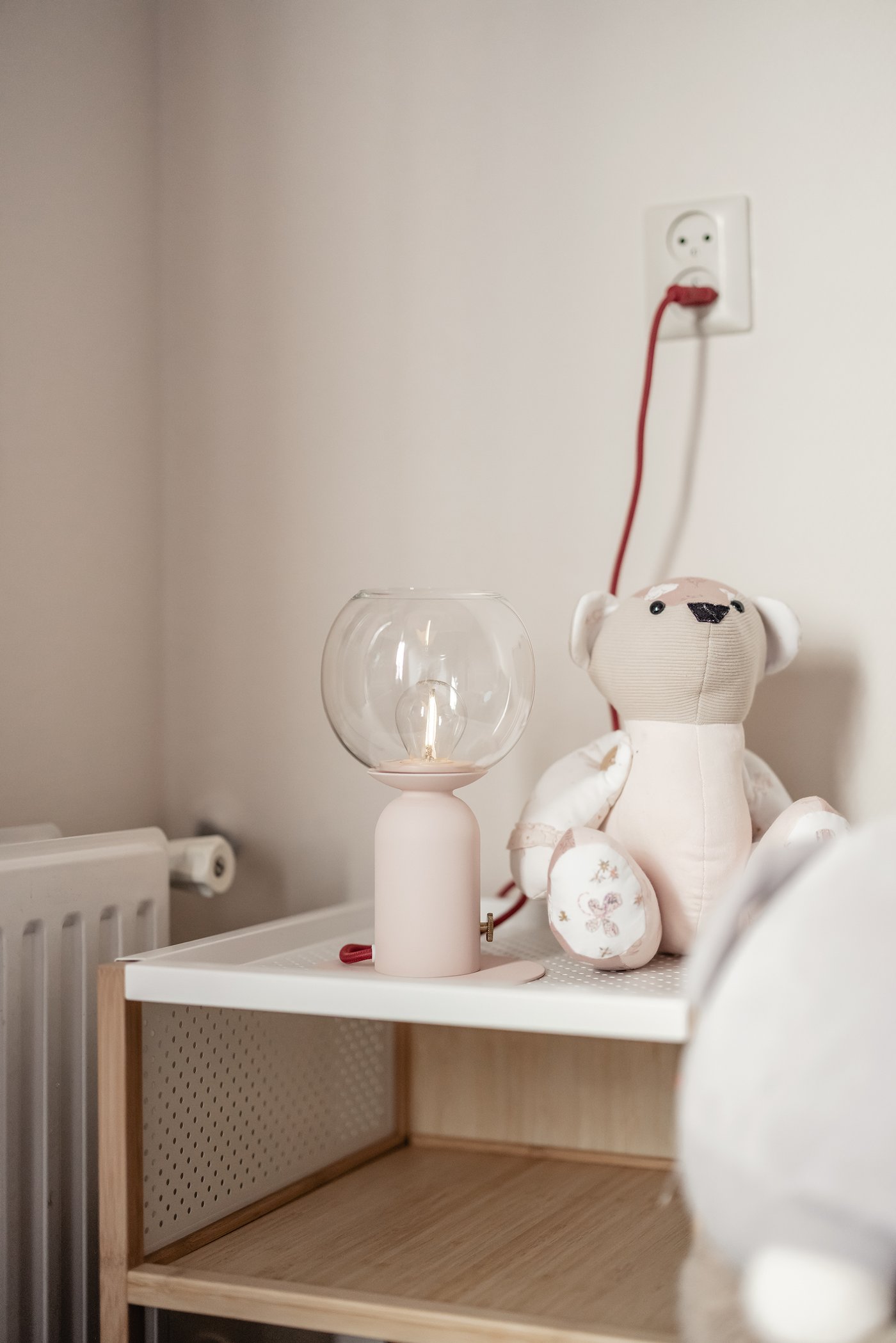 Een bamboe GILLERSBERG nachtkastje met daarop een lamp en een knuffel.