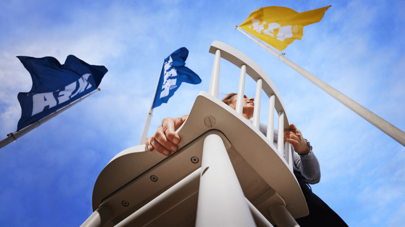 A customer carrying a white chair to an IKEA store to use the Buyback service.