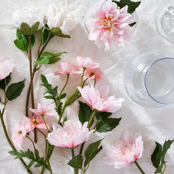 White peony SMYCKA artificial flowers and pink dahlia SMYCKA artificial flowers lie on a white surface.