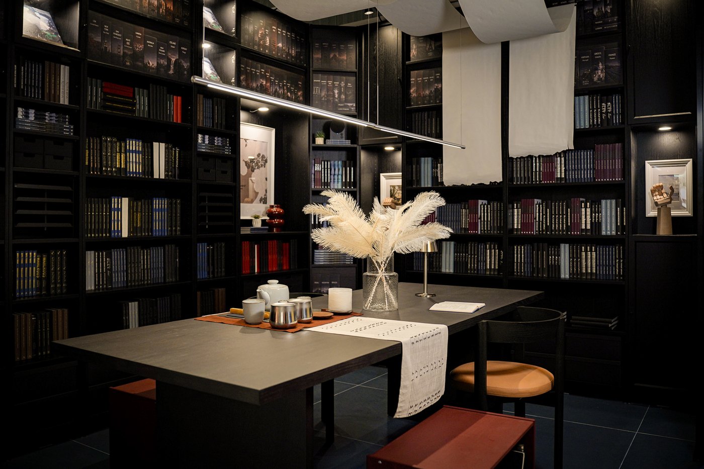 Curious Library room setting at IKEA Tampines, featuring a dark brown BERGSHYTTAN dining table, STOCKHOLM dining chair and black/brown BILLY bookcases filled with books.