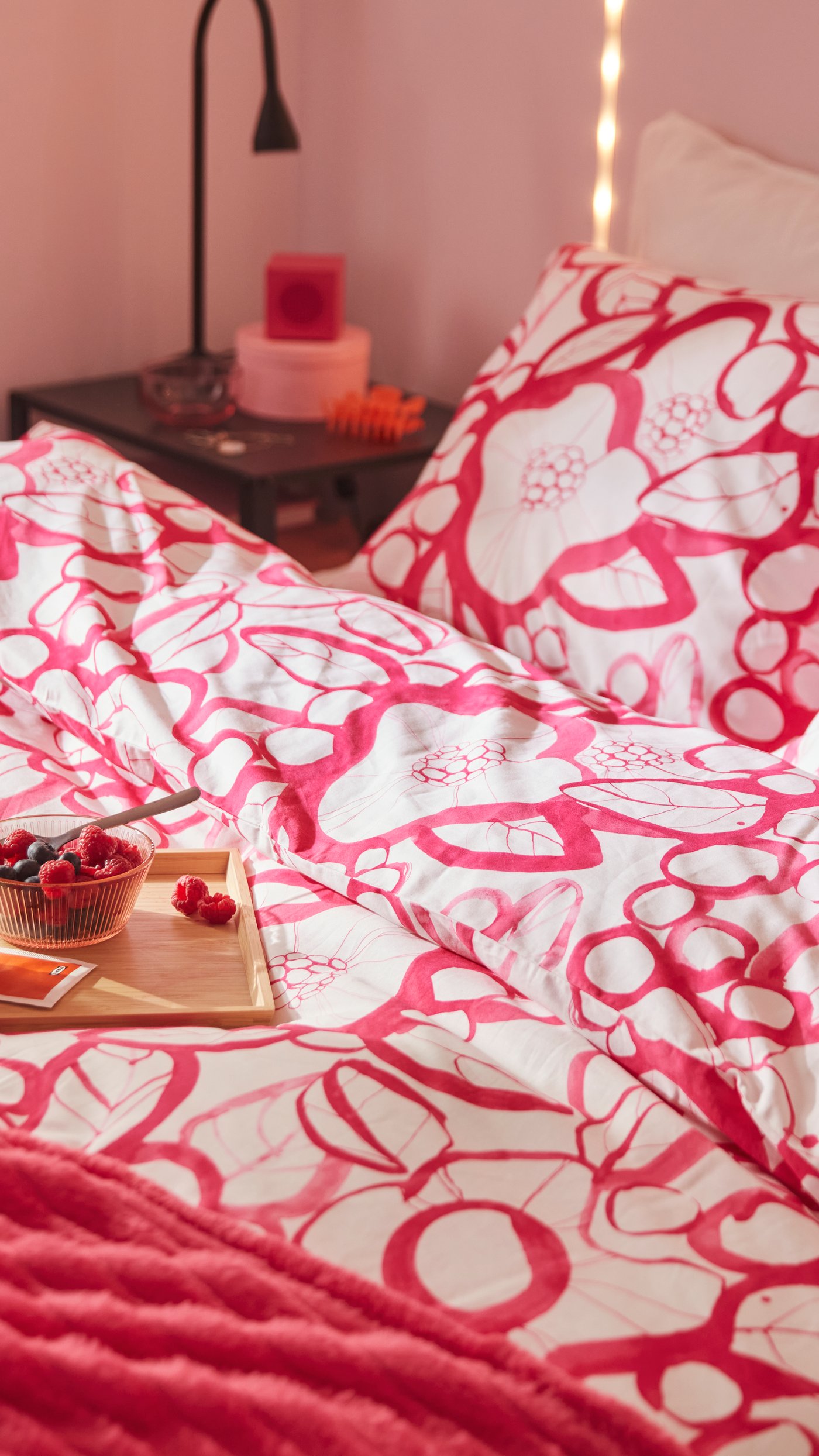 A pink KALLSUP portable Bluetooth speaker in the bedroom