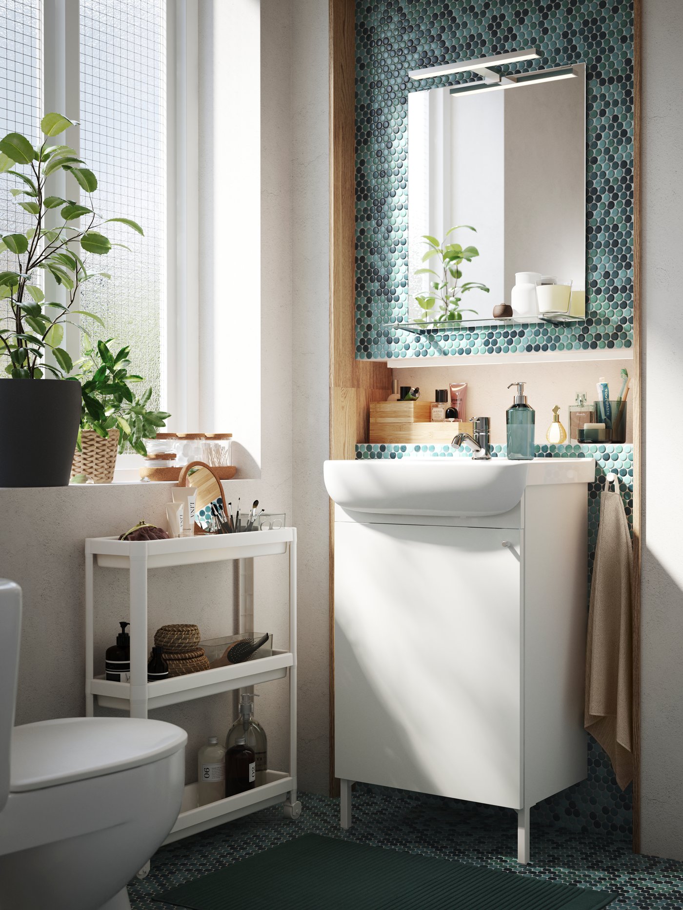Un baño con un mueble para lavamanos blanco de IKEA y al costado un carrito de baño plastivo VESKEN.
