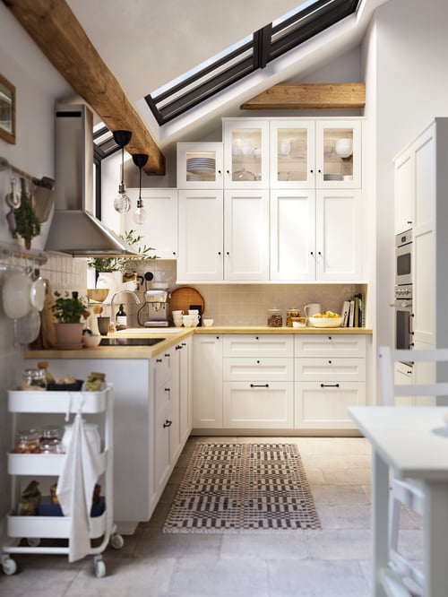 Kitchen featuring multiple white drawer fronts attached to base cabinets with worktop, wall cabinets, and an extractor hood.