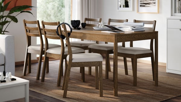 Ein Tisch und sechs Stühle aus Fridtuna hellbeigem TONSTAD mit braunem Eichenfurnier/brauner Eichenoptik.
