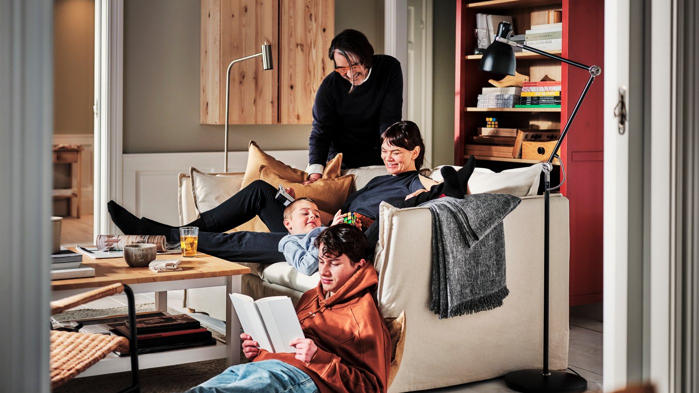 En familie sidder og hygger sammen på deres hvide sofa