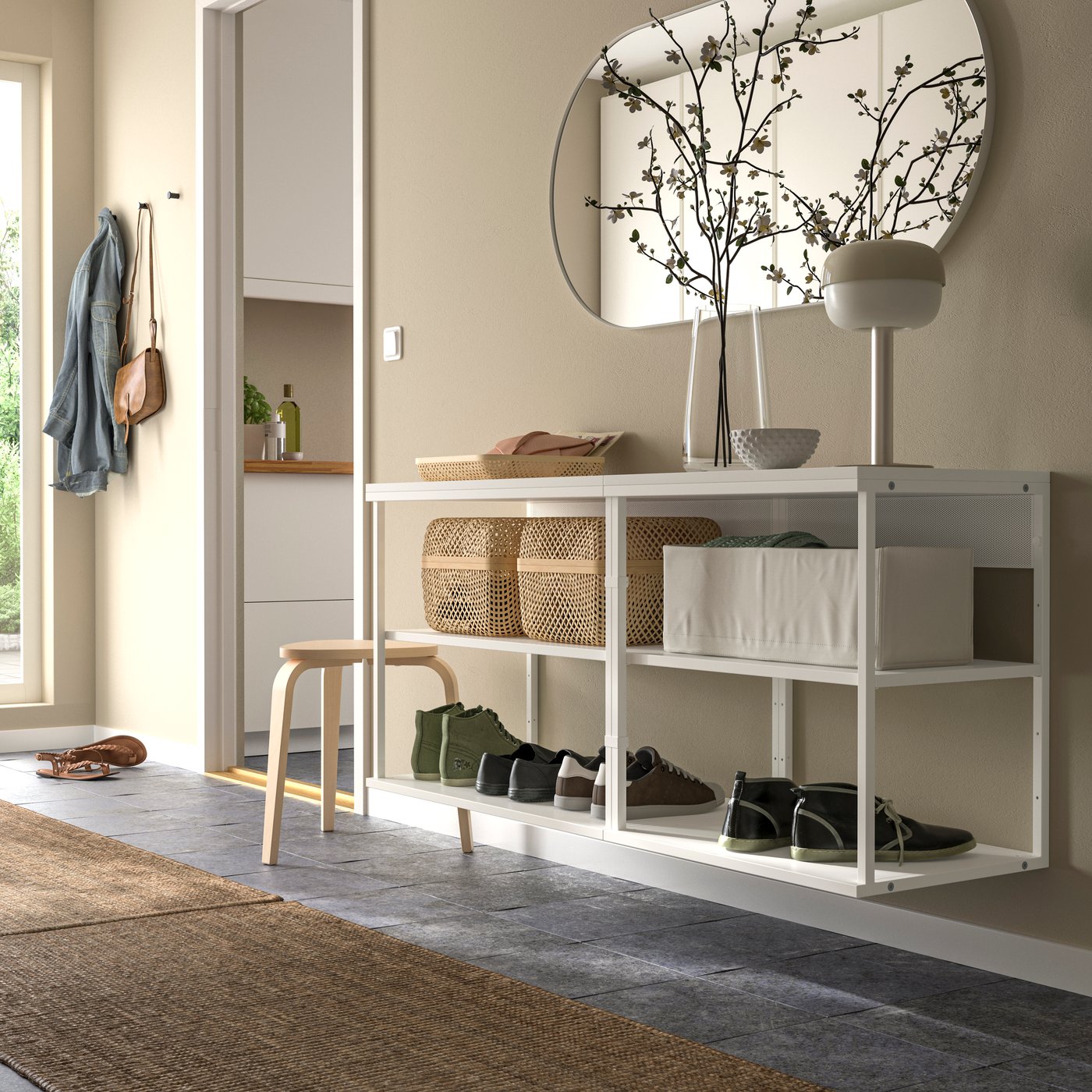 Heller Eingangsbereich mit weißer Ablagebank, dekorativen Körben, Schuhen und Wandspiege