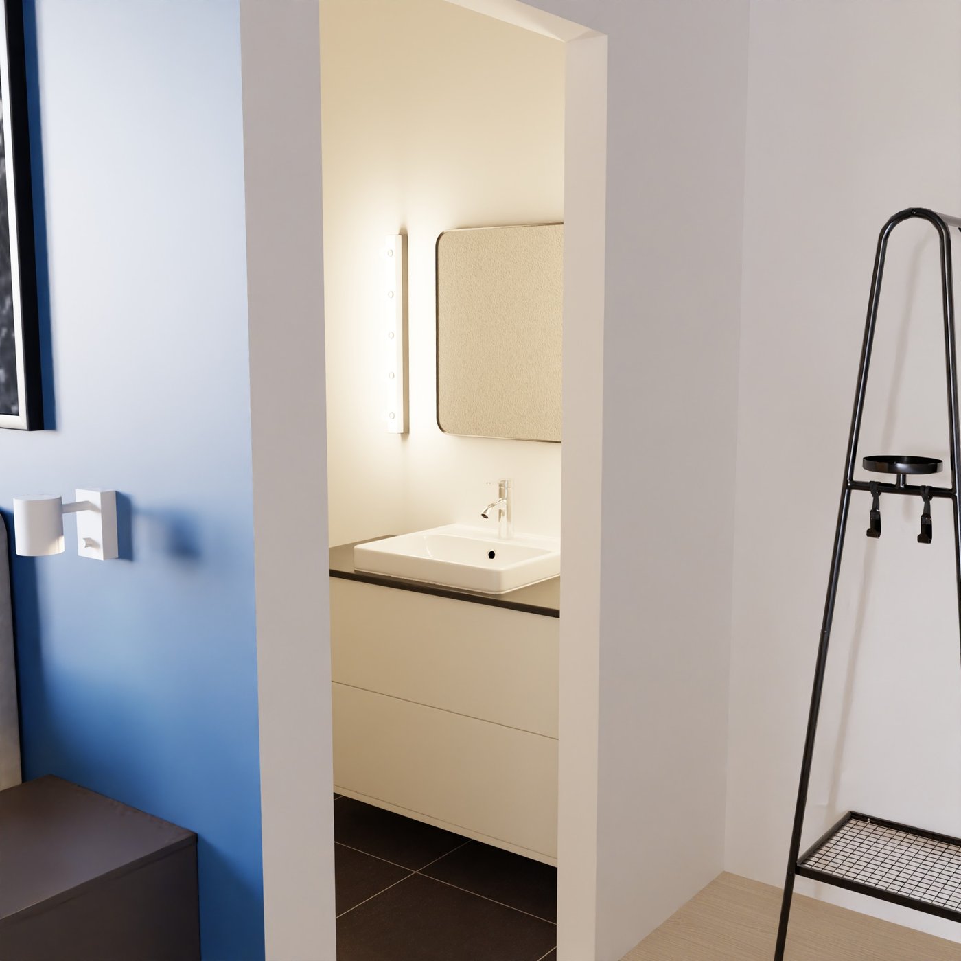 Teil eines Hotelzimmers. Links ein Teil eines Nachttischs. Mittig ein Blick in das Badezimmer auf einen Waschtisch mit zwei Schubladen. Rechts eine Garderobenlösung.