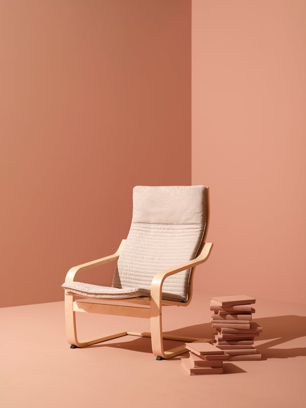 Una poltrona POÄNG beige in una stanza rosa.