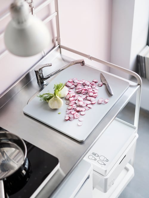 O bucătărie cu un robinet mixer de bucătărie cromat cu o singură pârghie din alamă, amplasat pe o mini bucătărie albă.
