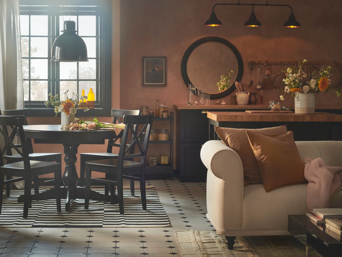 A rustic dining space with pink-coloured walls, a black INGATORP extendable table and four brown-black INGOLF chairs.