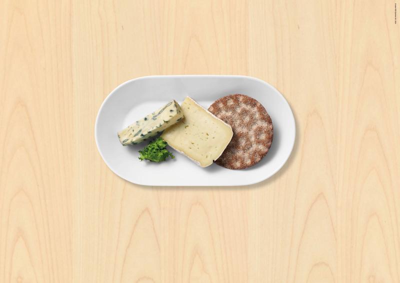 Assiette blanche avec deux morceaux de fromage dont un à moisissures, et un pain de seigle croquant.