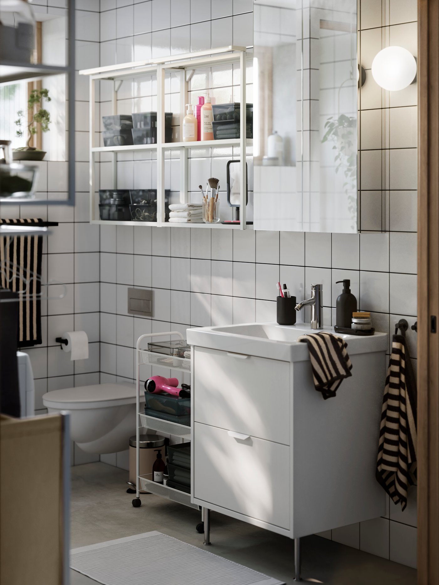 A modern small bathroom with white HAVBÄCK/ÖRRESJÖN storage, LETTAN mirror cabinet and white open ENHET shelves on the wall.