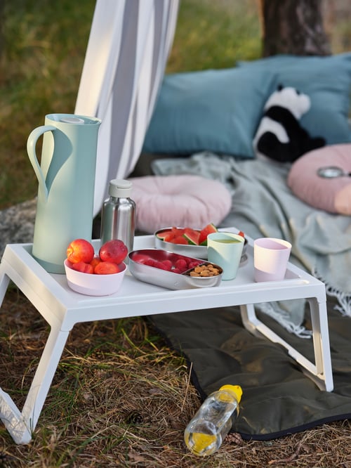 An ENKELSPÅRIG water bottle, HALVVARM food container, KALAS tumblers are on a white KLIPSK bed tray for snack time.