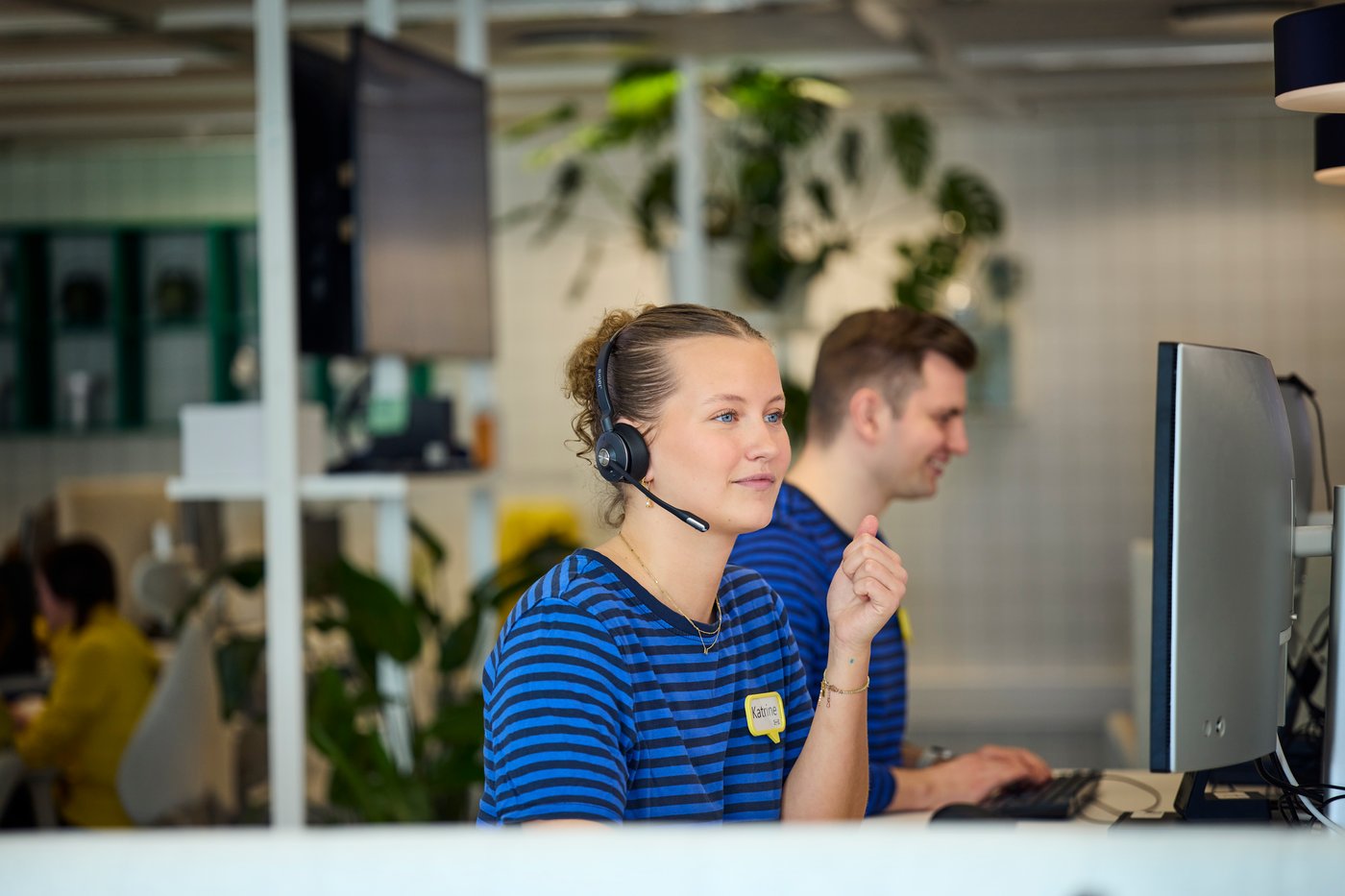 Een IKEA medewerker zit achter een computer met een headset op