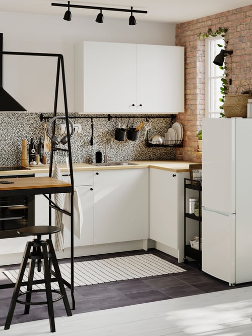 Moderne Küche mit einem KNOXHULT Unterschrank mit Türen und Schublade, zwei KNOXHULT Wandschränken mit Türen, einem LAGAN Kühl-/Gefrierschrank und einem HÅVERUD Tisch mit Aufhängemöglichkeiten.