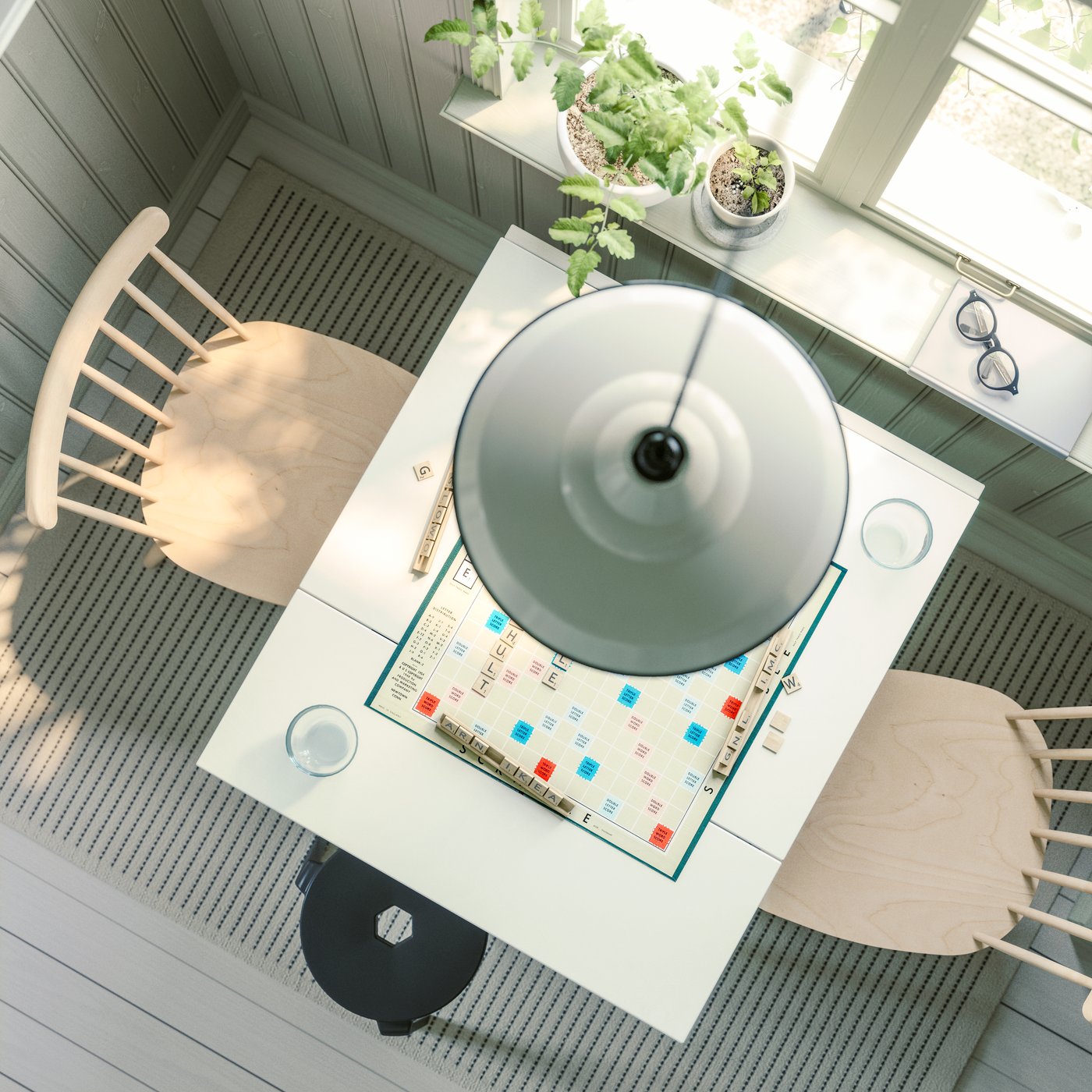 Vue d'ensemble d'une table à abattant HAUGA en blanc et placage de bouleau, avec des chaises HÖGVED, placée près d'une fenêtre.