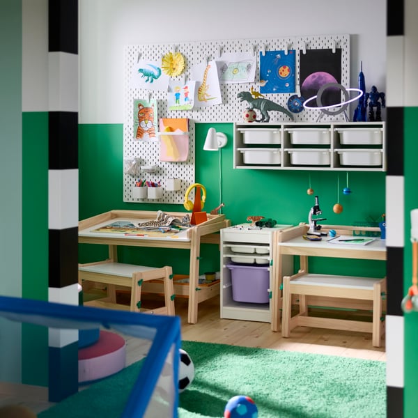 A FLISAT children’s bench placed in a study area with small desks, chairs and wall storage in a children’s room.