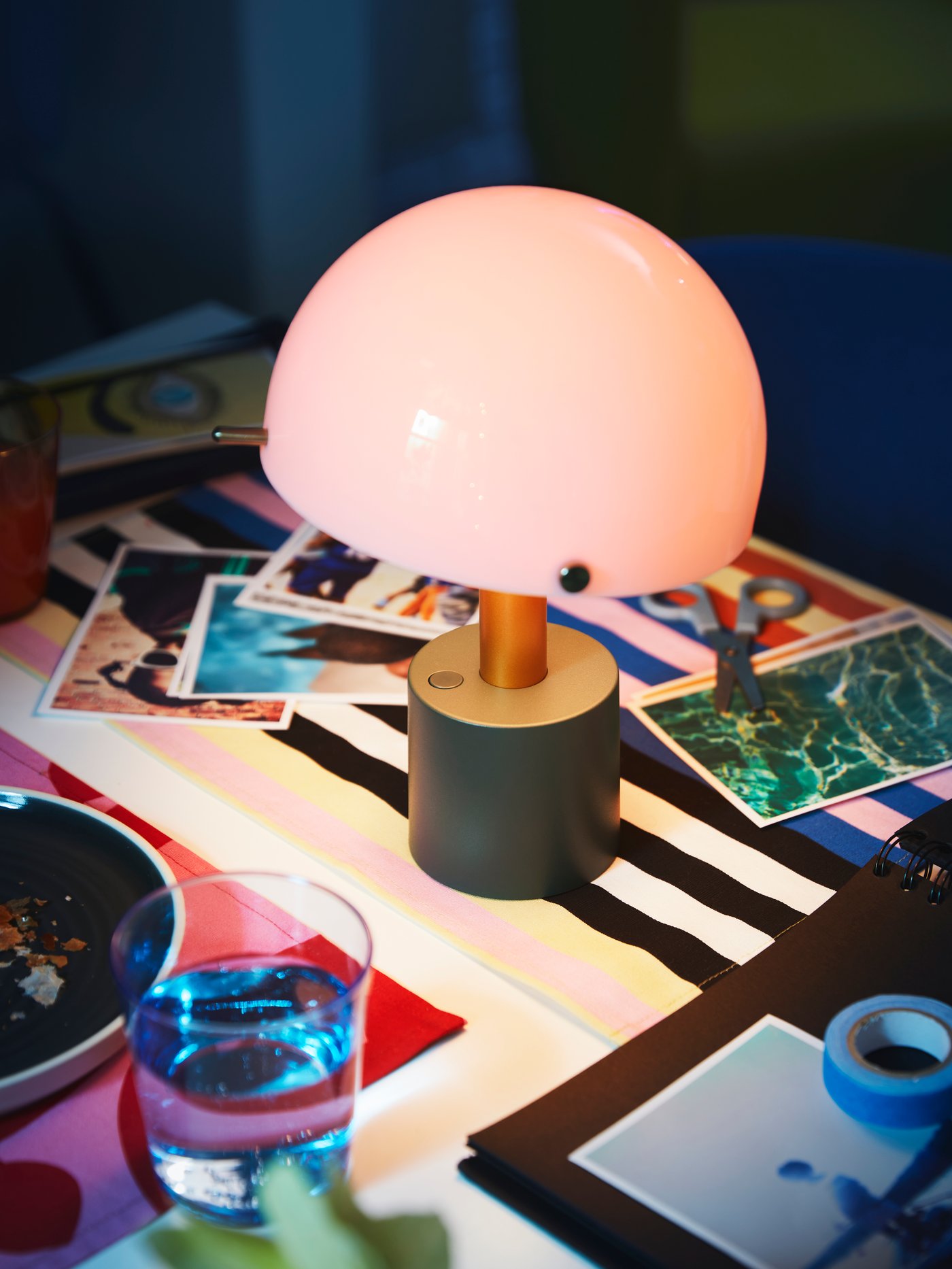 Deux suspensions REMTÅNG dans une pièce rose pâle. Lampe de table REMTÅNG sur un piédestal rose.