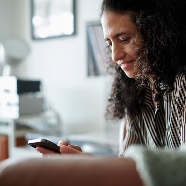 A woman looks on her smartphone