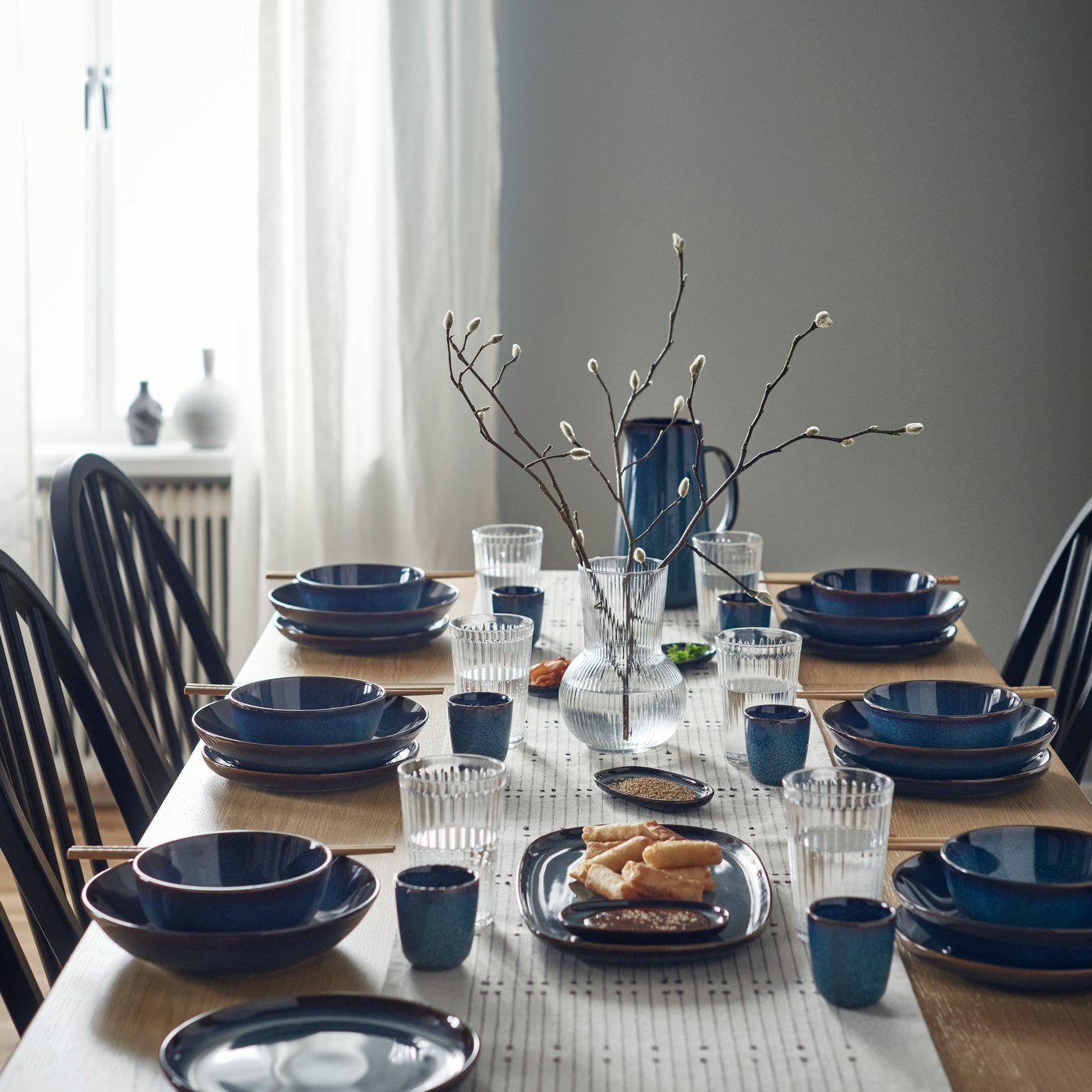 Ein Tisch gedeckt mit blauen GLADELIG Tellern, Schüsseln und Becher
