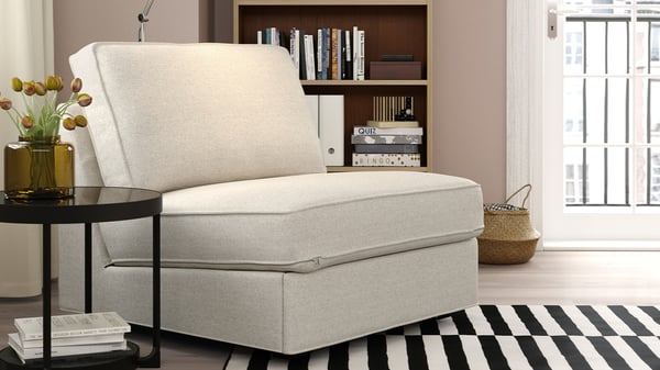 Ljusbeige KIVIK bäddfåtölj i ett modernt rum med randig matta.