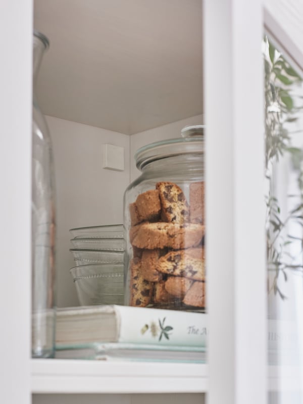 Detail of the interior of a HAVSTA storage combination with glass doors and the wall fixing cover.